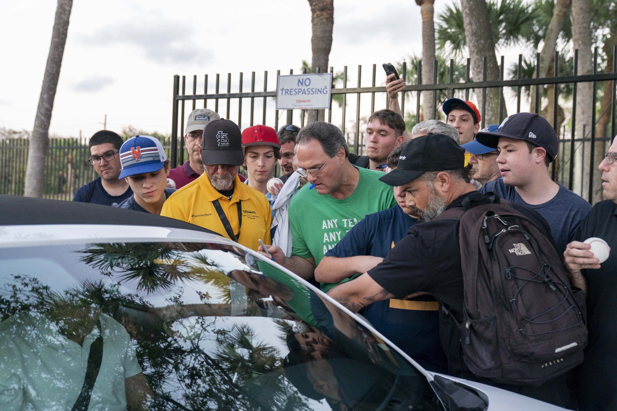 Baseball fans crowd around a car to get autographs from New York Yankees pitcher Gerrit Cole at Roger Dean Stadium in Jupiter, Florida on Feb. 23, 2022. (Greg Lovett/USA TODAY)