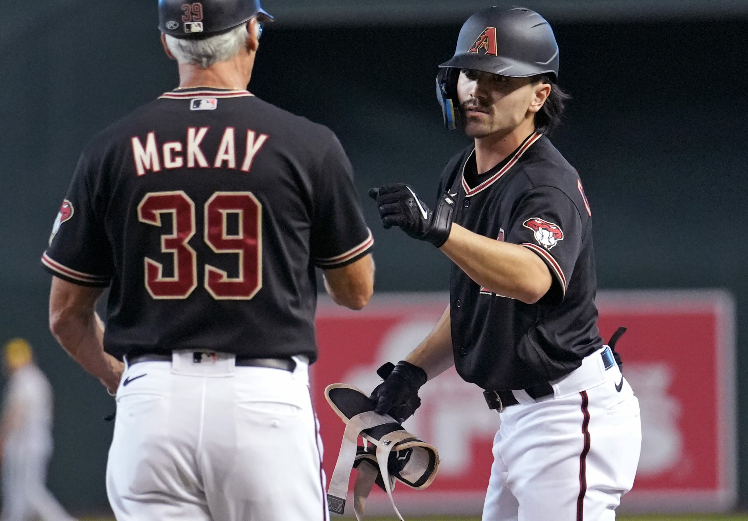 Diamondbacks outfielder Corbin Carroll fist bumps first base coach Dave McKay after his RBI single against the Milwaukee Brewers at Chase Field. (Joe Rondone/Arizona Republic)